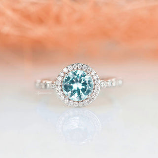 Aquamarine Ring- Sterling Silver by Aquamarise, showcasing a vibrant round aquamarine center surrounded by sparkling accents on a delicate sterling silver band, elegant for promise or engagement.