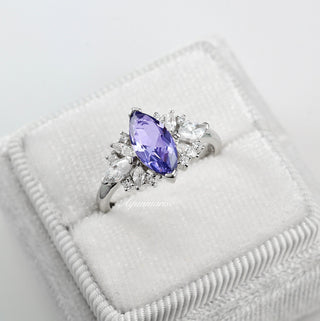 Adeline Marquise Cut Tanzanite Ring in Sterling Silver by Aquamarise, featuring a marquise-cut violet tanzanite accented with pear and round white gemstones on a polished sterling silver band.